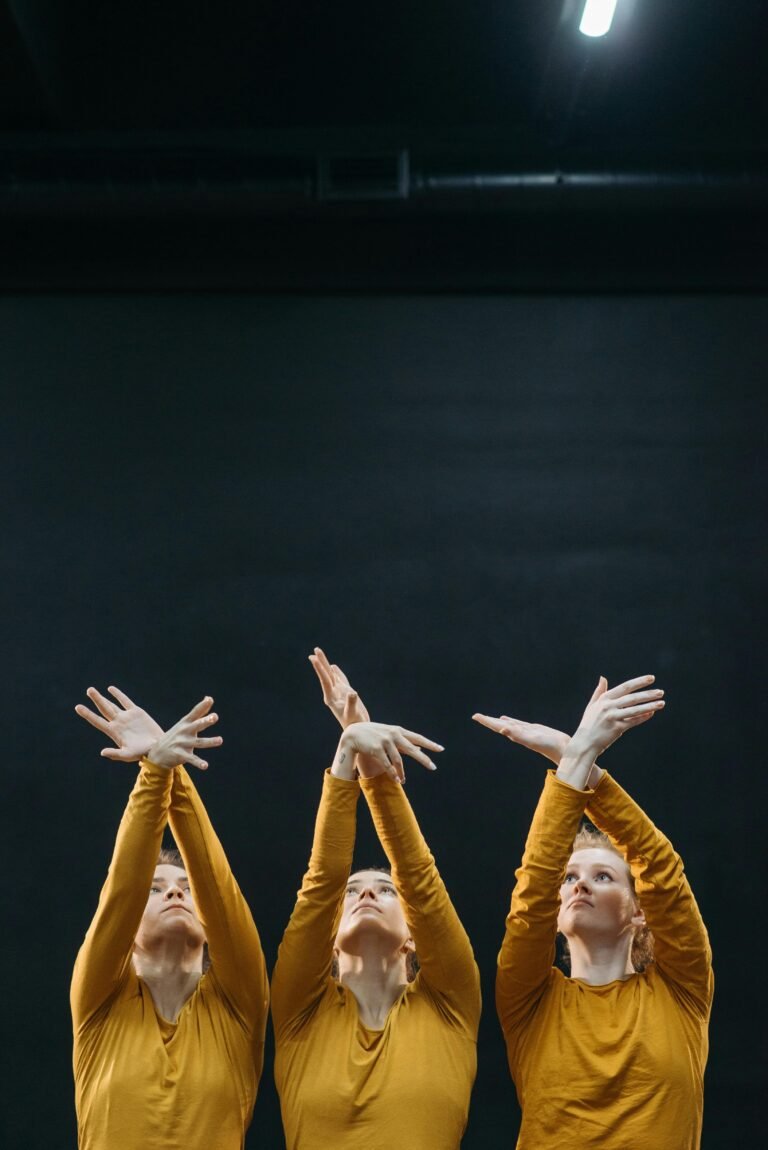 Three dancers in synchronized motion, expressing grace and creativity indoors.